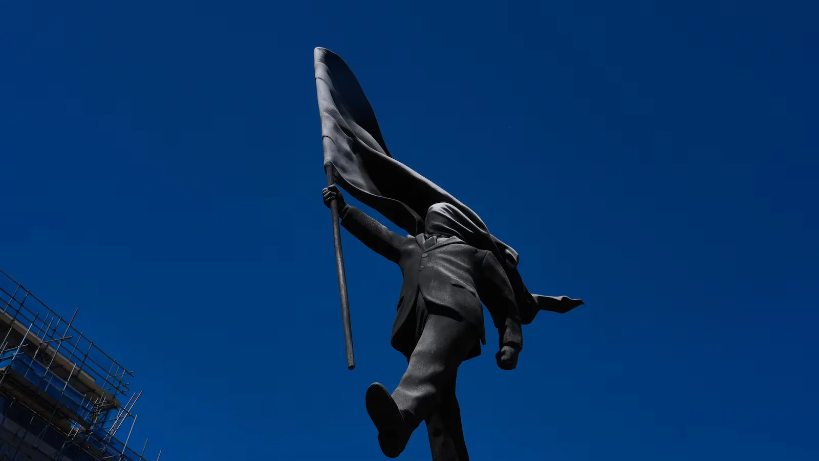 Banksy claims London statue: man blinded by flag strides off its plinth