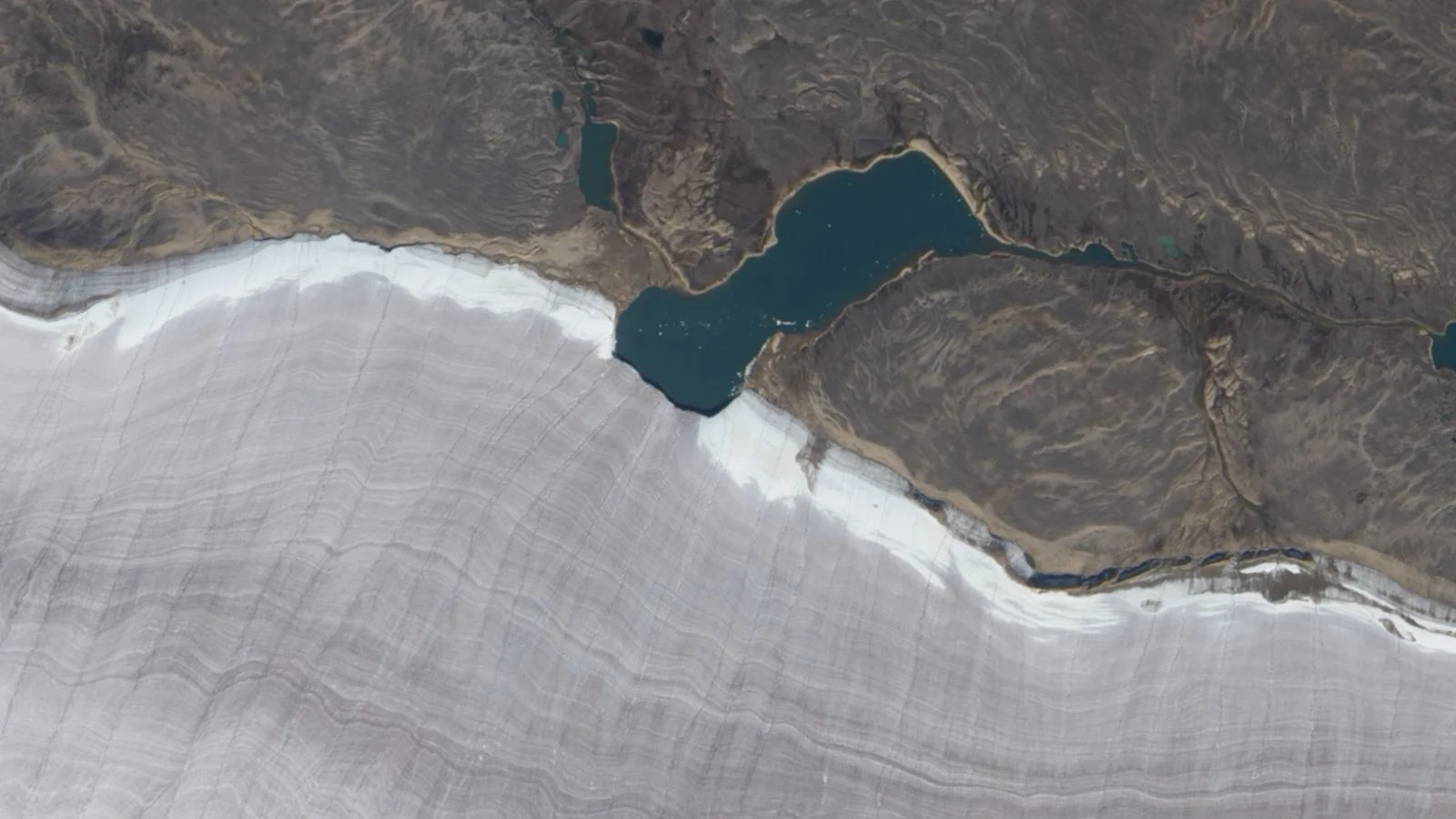 Tiny Arctic lake slices Canada's oldest ice cap, seen from space