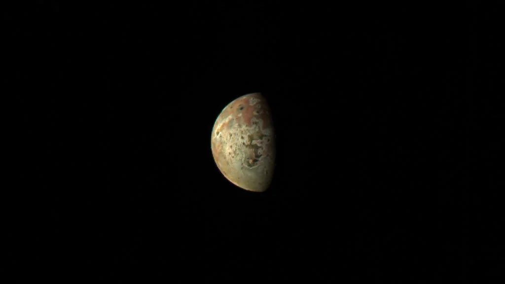 Juno spacecraft approaches Jupiter's moon Io.